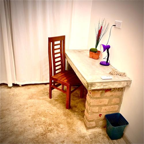 a wooden table with a chair and a lamp and a lamp at Mirage Beach House at Morava Court in Hikkaduwa