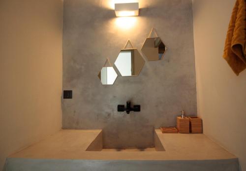 ein Badezimmer mit einem Waschbecken und zwei Spiegeln an der Wand in der Unterkunft New Guesthouse in Emporios in Emporeiós