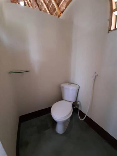 a bathroom with a white toilet in a room at Tangi Safari Lodge in Pakwach East