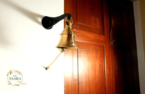 a bell hanging on the door of a room at La Taara - Feel Home in Auroville