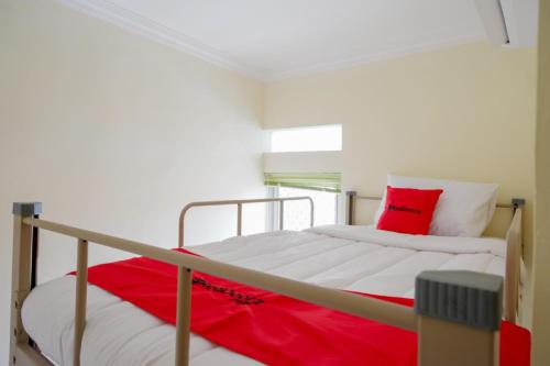 a bedroom with a bed with a red pillow at RedDoorz Hostel near Kota Lama Semarang in Semarang