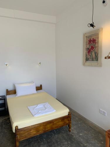 a bed in a room with a picture on the wall at Mirage Beach House at Morava Court in Hikkaduwa