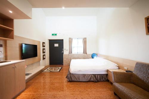 GukengにあるPalm Island B&Bのベッド、ソファ、テレビが備わる客室です。