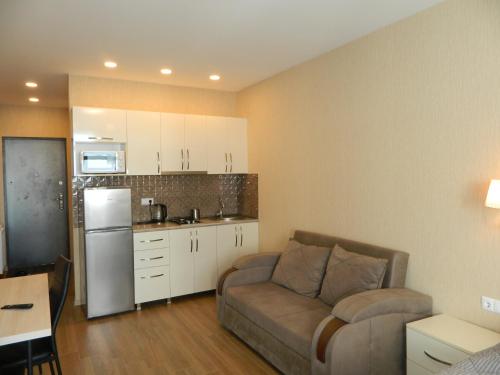 a living room with a couch and a kitchen at Апартамент с видом на море in Batumi