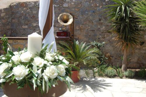 a bouquet of white roses in front of a stone wall at Guesthouse Kellia in Monemvasia