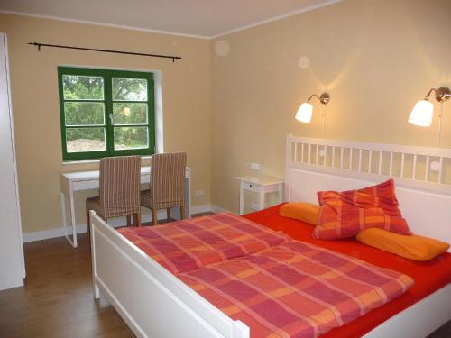 a bedroom with a bed and a table and a window at Ostsee-Bauernhof-Hocke in Benz