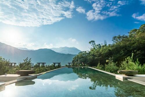 a swimming pool with mountains in the background at The Bale Villas牛眠埔里 in Puli