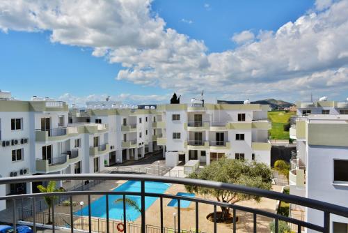 - une vue depuis le balcon d'un immeuble avec piscine dans l'établissement Oceania Bay Village, à Pýla