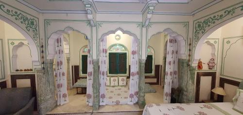 a room with two beds and a mirror in it at Jaipur Haveli in Jaipur