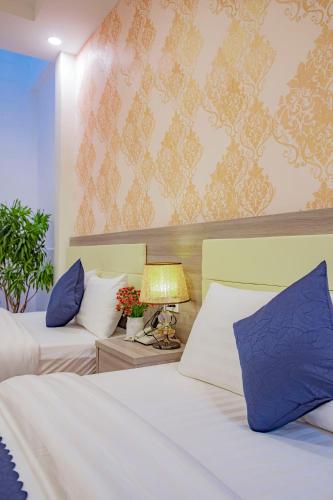 a hotel room with two beds and a lamp at Khanh Uyen 1 Hotel in Da Lat