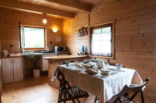 una cocina con mesa en una casa de madera en Chatka w gorach en Lewin Kłodzki