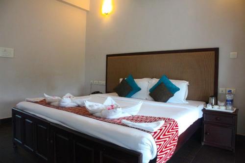 a bedroom with a large bed with four rabbits on it at Kalathil Lake Resort in Vaikom