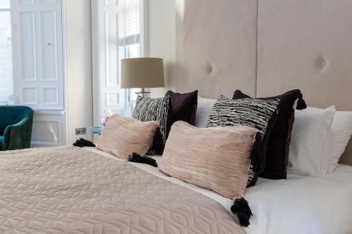 a bedroom with a white bed with pillows at The Lane Hotel in Edinburgh
