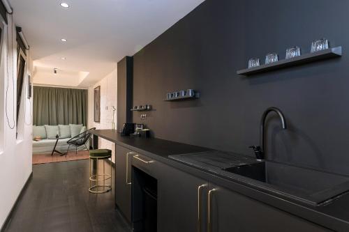 a black kitchen with a sink and a counter at Nin&Bau Sarri 2 in Athens