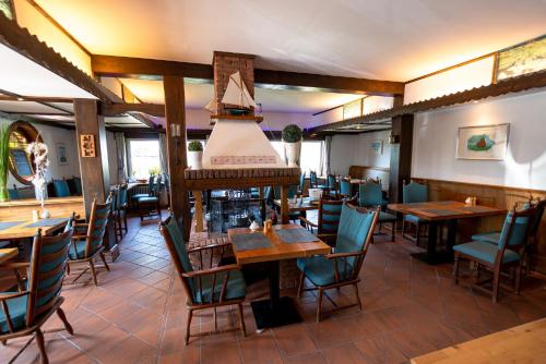 a restaurant with wooden tables and chairs and a ceiling at Wohlfühlhotel Hörn van Diek Garni mit Schwimmbad in Bensersiel