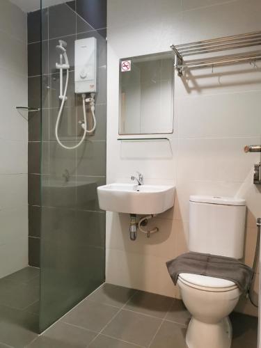 a bathroom with a toilet and a sink and a shower at Hotel Alpha in Bukit Mertajam