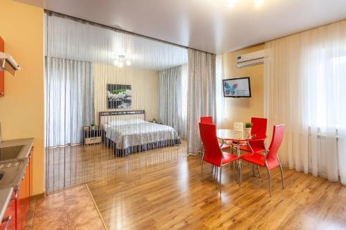 a room with a table and chairs and a bed at Апарт-отель 7 этажей Тюмень Центр in Tyumen