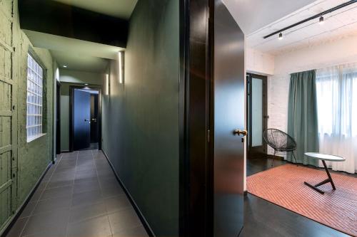 a hallway with a door and a chair in a room at Nin&Bau Sarri 2 in Athens
