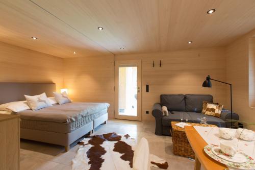 a bedroom with a bed and a couch at Gartenstudio Waldblick in Schwarzenberg