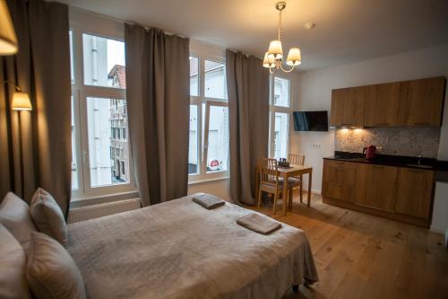 1 dormitorio con 1 cama y cocina con mesa en Luxury Suites Riverside Residence en Amberes