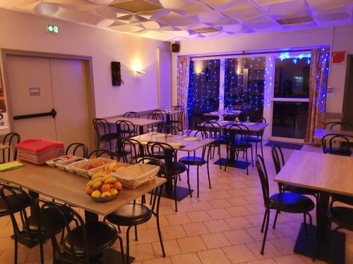 une salle à manger avec des tables, des chaises et des lumières violettes dans l'établissement Le Toul' Broch, à Baden