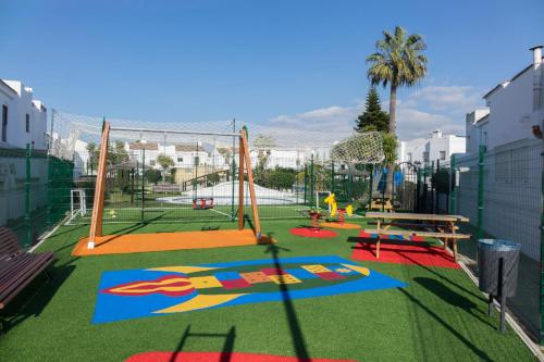 an empty playground with a swing set on the grass at Casa Real la Barrosa in Chiclana de la Frontera