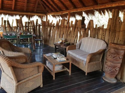 a living room with chairs and a couch and a table at Quatermain's 1920's Safari Camp – Amakhala Game Reserve in Amakhala Game Reserve