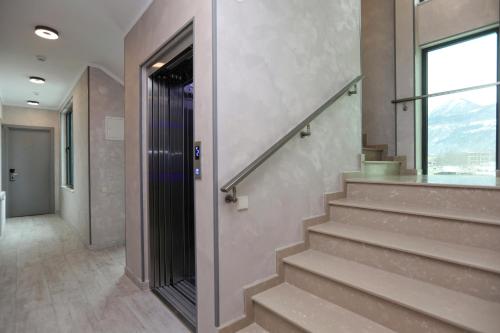 a staircase in a building with a window and a door at Sunset Terrace Mestia in Mestia