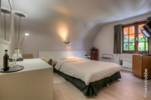 a bedroom with a bed and a sink in it at JFK Hotel Zelzate - Gent in Zelzate