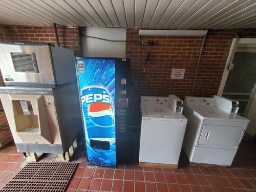 a pepsi cola vending machine sitting next to two washers at Relax Inn in Emporia