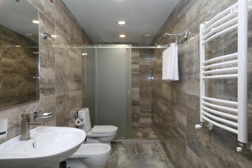 a bathroom with a sink and a toilet and a shower at Sunset Terrace Mestia in Mestia