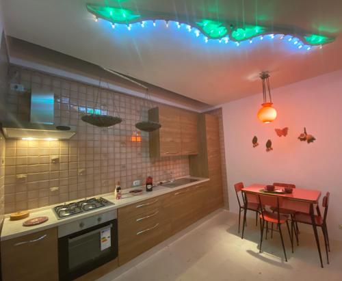 a kitchen with a red table and a kitchen with green lights at DON GIL CHIC in Polignano a Mare