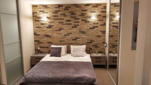 a bedroom with a bed and a brick wall at Old Riga Modern Apartment in Riga