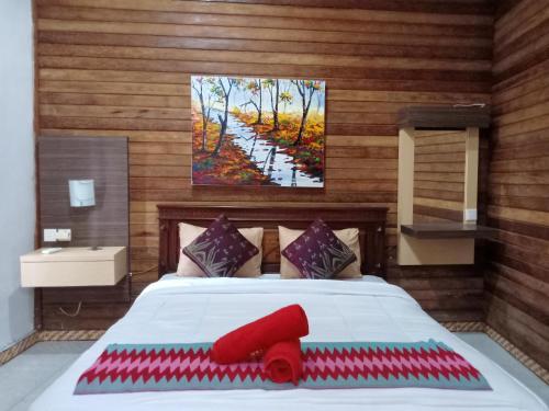 um quarto com uma grande cama branca com um quadro na parede em The Mel Homestay em Nusa Penida