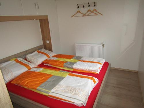 1 dormitorio con 2 camas y mantas coloridas en Mobilheim Adler Horst en Lachtal