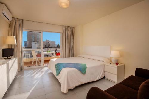 a hotel room with a bed and a balcony at Apartamentos Nucleo Cristal in Torremolinos