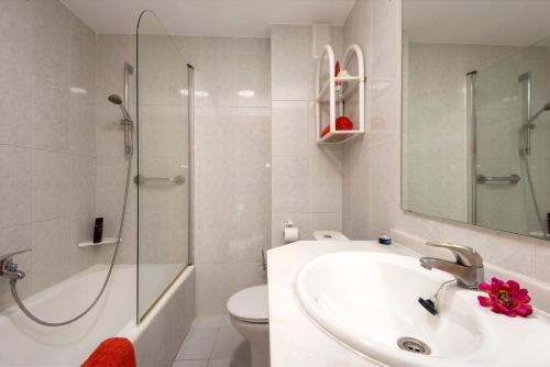 a bathroom with a sink and a shower and a toilet at Apartamentos Nucleo Cristal in Torremolinos
