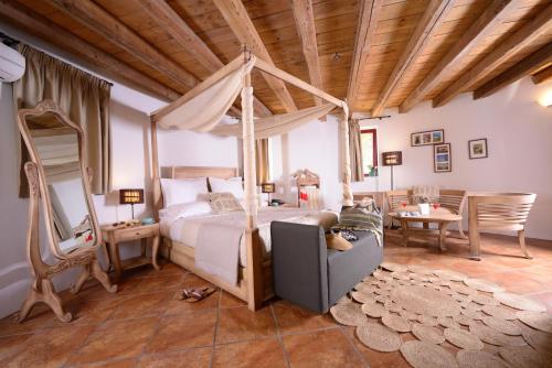 a bedroom with a canopy bed and a table at Varos Village Boutique Hotel in Város