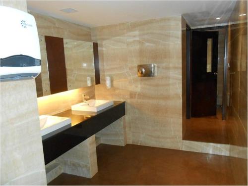 a bathroom with two sinks and a mirror at The South Park Hotel in Trivandrum