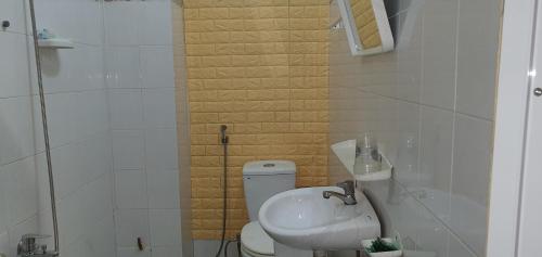 a white bathroom with a sink and a toilet at NHÀ NGHỈ VIỆT NGA in Ha Tien