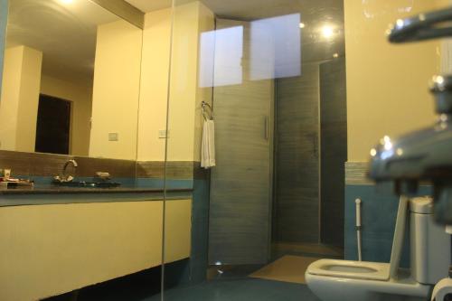 a bathroom with a toilet and a glass shower at Hotel One Bahawalpur in Bahawalpur