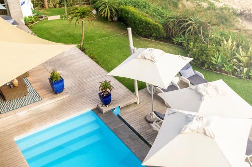 an overhead view of a swimming pool with umbrellas at Beach Villa Wilderness in Wilderness