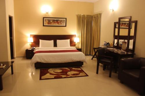 a hotel room with a bed and a desk and a desk at Hotel One Bahawalpur in Bahawalpur