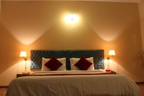 a bedroom with a large bed with red pillows at Hotel One Bahawalpur in Bahawalpur