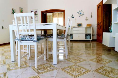 Pizzo的住宿－Casadamarepg Gallipoli，厨房配有白色的桌子和两把椅子