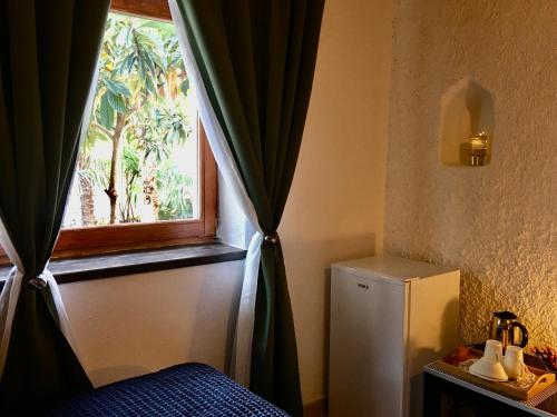 una stanza con una finestra e un piccolo frigorifero di Palmera a Mostar
