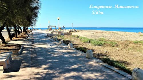 a park with benches and a playground on the beach at Casadamarepg Gallipoli in Pizzo