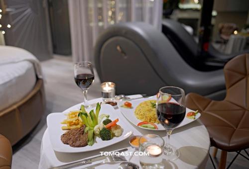 a table with two plates of food and two glasses of wine at Bonita Boutique Hotel in Ho Chi Minh City