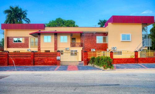 une maison avec une clôture rouge devant elle dans l'établissement Riando appartement Royal Rainville, à Paramaribo