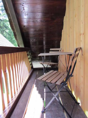 a picnic table and a bench on a porch at Počitniška hiša Koča Dobnik in Lovrenc na Pohorju